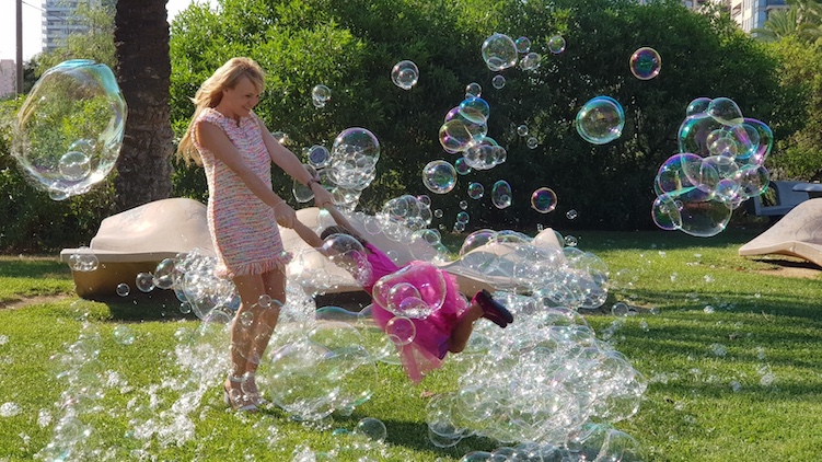 La belleza de una nube de burbujas gigantes volando encima de sus cabezas